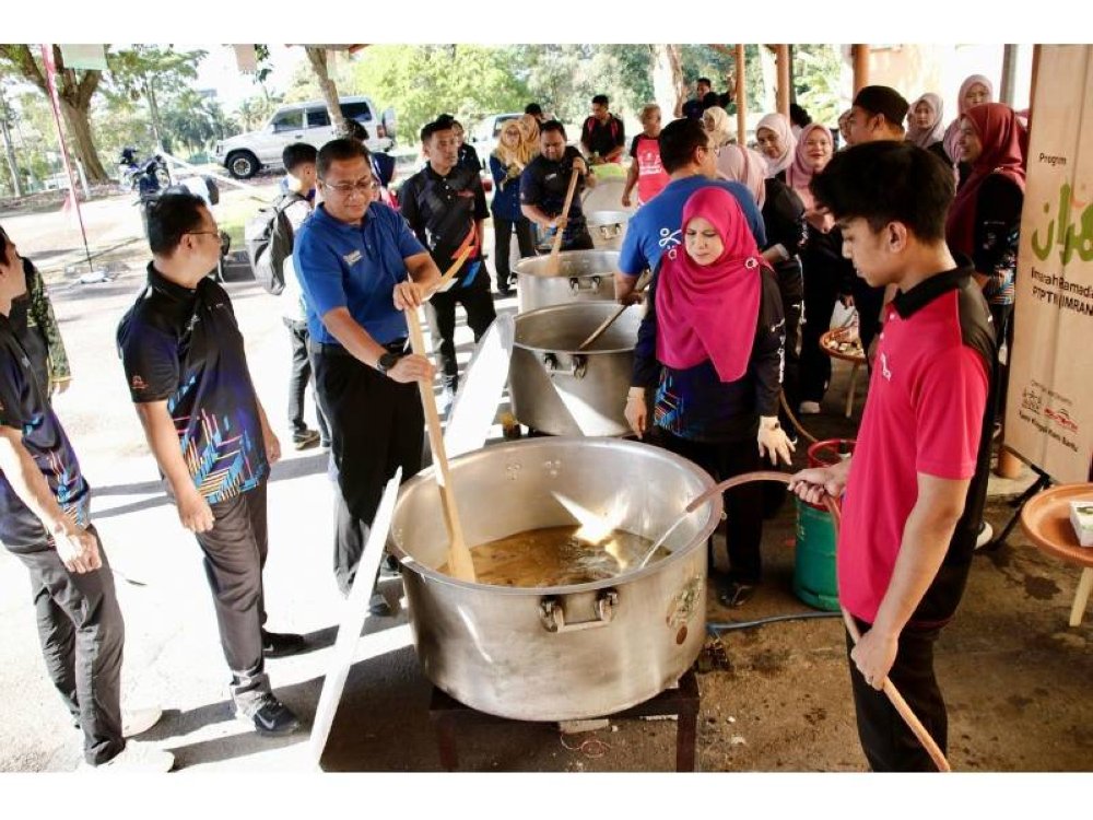 MELAKA - Penyediaan bubur lambuk oleh Ketua Operasi Kewangan PTPTN, Azhar Ahmad (tengah) bersama warga kerja Politeknik Merlimau Melaka.