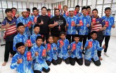 Wan Ahmad (berdiri, tengah) bergambar bersama pelajar.