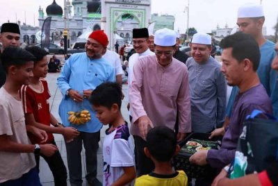 Tengku Sarafudin Badlishah (tengah) berkenan mengagihkan juadah berbuka puasa kepada pengunjung yang hadir di Dataran Medan Bandar Alor Setar pada petang Khamis. - Foto Kedah Tourism