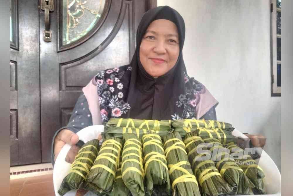 Haifah menunjukkan ketupat daun tebu yang menjadi menu utama keluarga pada pagi Hari Raya Aidilfitri.