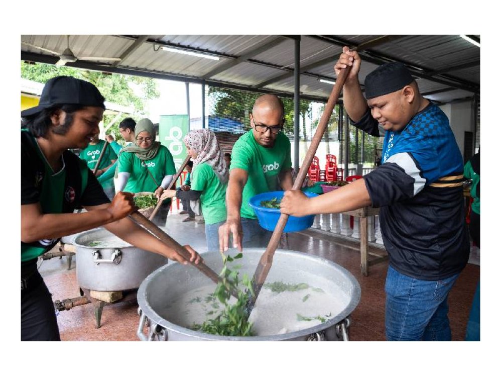 Gotong royong memasak bubur lambuk disertai oleh Grab Malaysia dan rakan kongi.