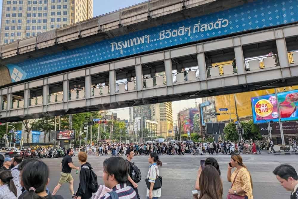 Orang ramai berjalan di sepanjang persimpangan trafik selepas perkhidmatan kereta api BTS dihentikan sementara di Bangkok susulan gempa bumi. Foto AFP