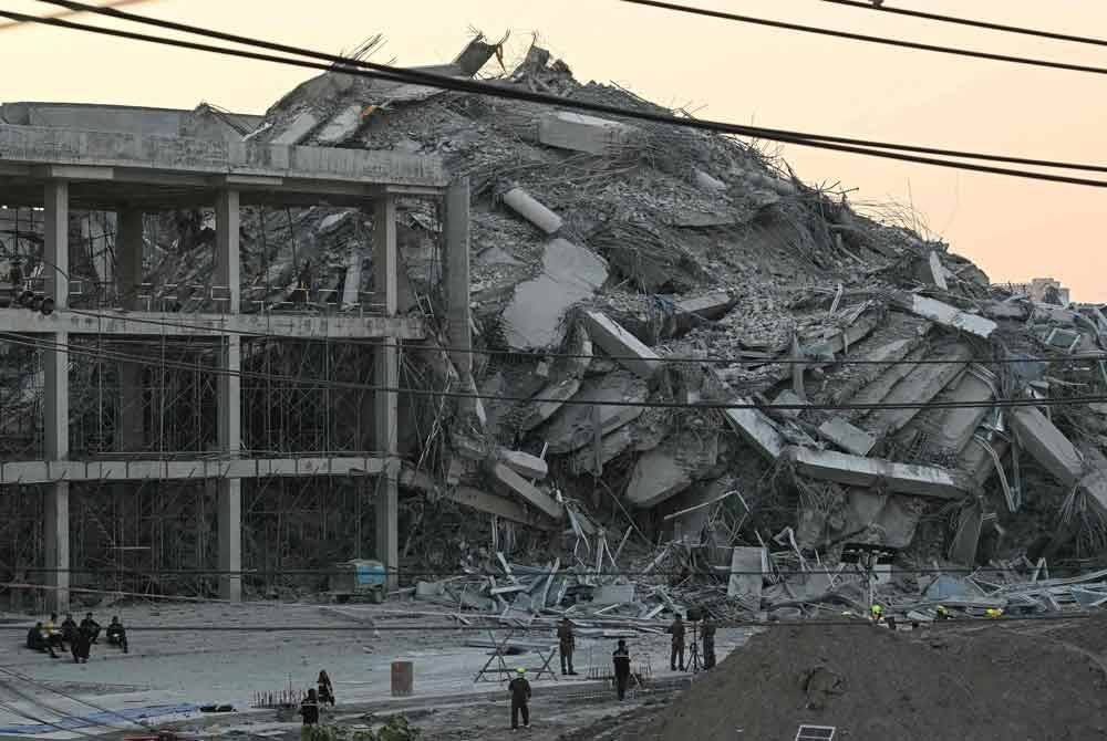 Pasukan perkhidmatan kecemasan meninjau lokasi bangunan runtuh di Bangkok. Foto AFP