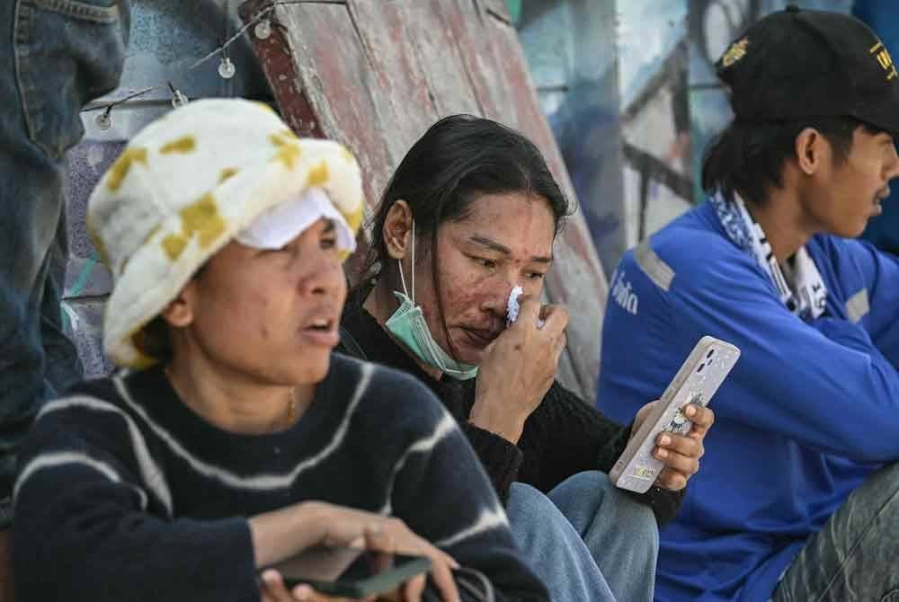 Orang ramai menunggu berita tentang ahli keluarga mereka di lokasi runtuhan bangunan yang sedang dalam pembinaan di Bangkok. Foto AFP