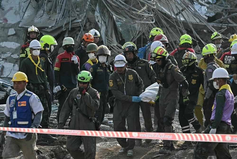 Pekerja penyelamat mengusung mayat mangsa di lokasi runtuhan bangunan yang sedang dalam pembinaan di Bangkok. Foto AFP