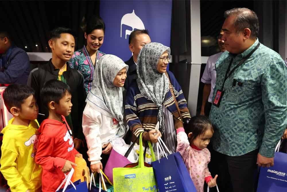 Anthony (kanan) pada program penyampaian goodies raya kepada penumpang pesawat Malaysia Airlines MH7404 ke Kota Kinabalu dan menyantuni penumpang yang akan pulang ke kampung halaman sempena Hari Raya Aidilfitri di Lapangan Terbang Antarabangsa Kuala Lumpur (KLIA) Terminal 1 pada Jumaat. Foto Bernama