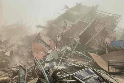 Orang ramai memeriksa runtuhan bangunan yang roboh di Mandalay selepas kejadian gempa bumi. Foto AFP