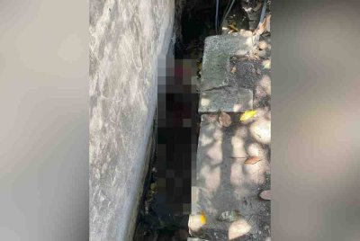 Seorang lelaki tanpa identiti ditemui mati dalam keadaan tersepit dalam longkang di Lebuh Bercham Timur, Pusat Bandar Baru Bercham, Ipoh pada Sabtu. Foto Bomba Perak