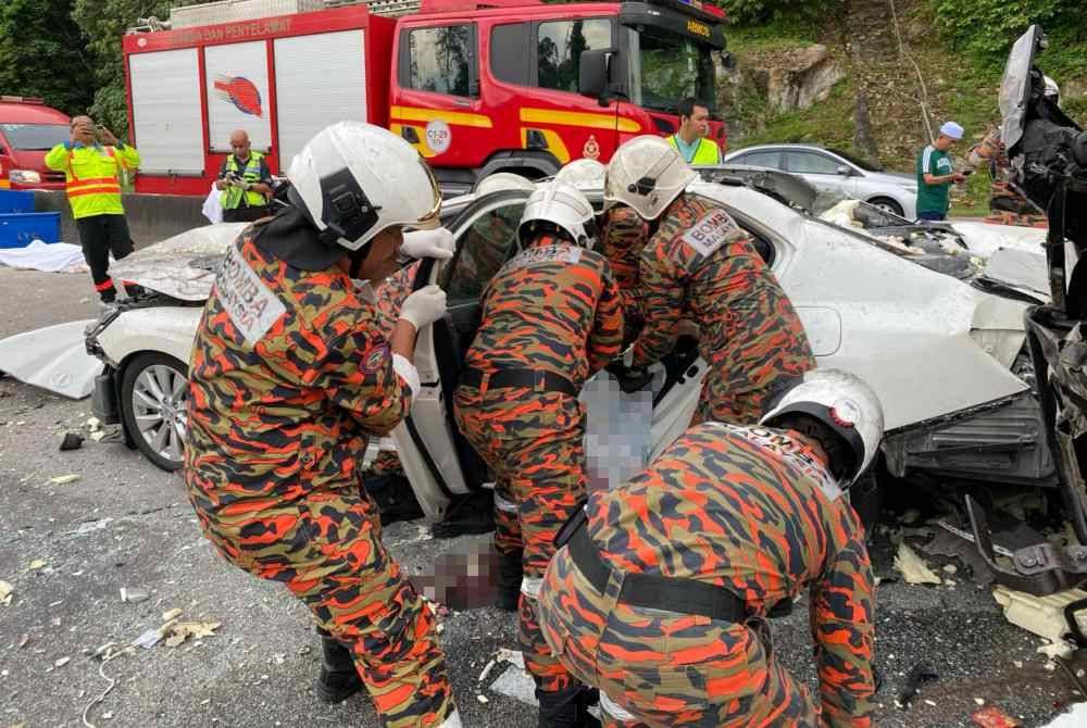 Anggota bomba membantu mengeluarkan mangsa yang tersepit selepas terlibat nahas di Kilometer 50.7 Lebuhraya Kuala Lumpur-Karak dekat Bentong pada Ahad.