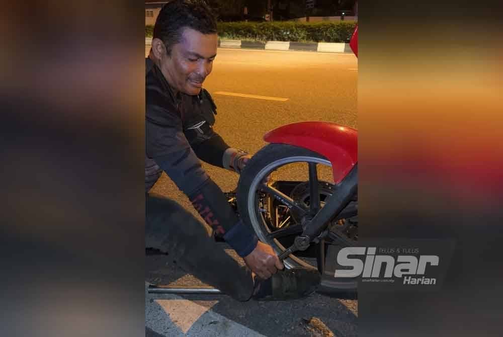 Zaki membaiki tayar motosikal pada waktu malam.
FOTO SINAR HARIAN-ADILA SHARINNI WAHID