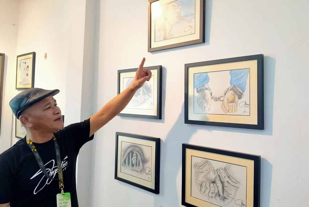 Shahrun Nahar menunjukkan beberapa karya dari artis residen Signature Art di Taman Muda, di sini.