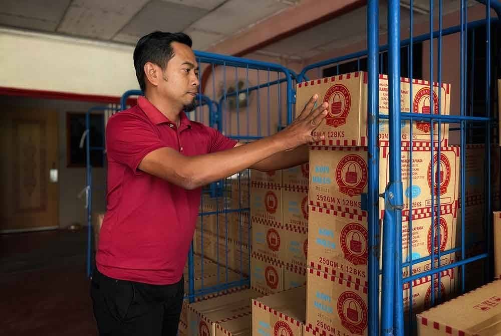 Najmuddin sedang memeriksa stok kopi untuk dihantar ke kedai runcit seluruh Kedah.