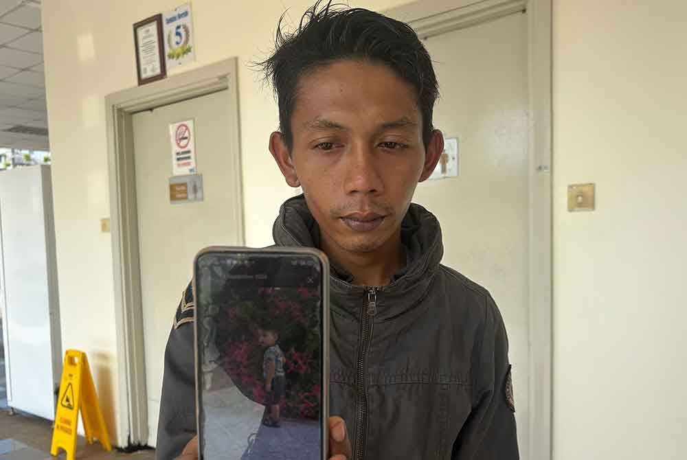 Mohd Fakhri menunjukkan gambar anaknya yang disimpan dalam telefon bimbitnya
