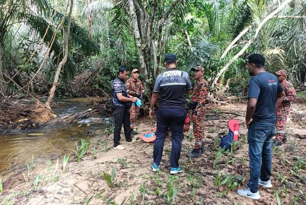 Anggota polis mengangkat mayat lelaki yang ditemui hanyut dalam Sungai Lubok Kedondong di Tangkak pada Selasa.