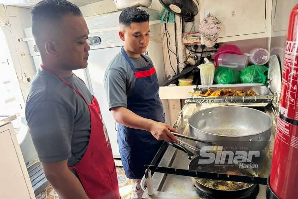 Mohd Saiful (kiri) memantau anggota memasak di kapal. FOTO SINAR HARIAN-ADILA SHARINNI WAHID