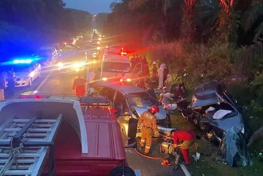Anggota bomba melakukan kerja-kerja mengeluarkan mangsa yang terlibat dalam kemalangan di Kilometer 25 Jalan Renggam - Layang-Layang pada malam Isnin.
