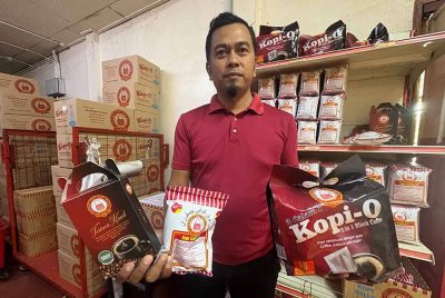 Najmuddin menunjukkan jenis pembungkusan kopi keluaran syarikat mereka.