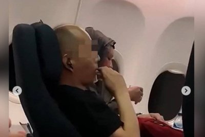 Gelagat penumpang lelaki tersebut yang secara terang-terangan melanggar peraturan sewaktu menaiki pesawat. Foto Agensi
