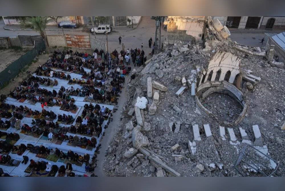 Penduduk Gaza menunaikan solat di lokasi berhampiran masjid yang musnah dibedil.