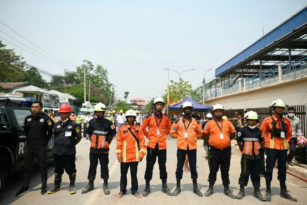Anggota penyelamat bertafakur selama seminit semasa upacara itu yang diadakan berhampiran lokasi terjejas gempa pada Selasa. Foto AFP