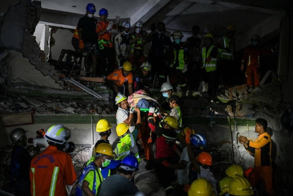 Antara mangsa yang berjaya dibawa keluar daripada timbunan runtuhan bangunan di Mandalay selepas tempoh 48 jam. Foto AFP