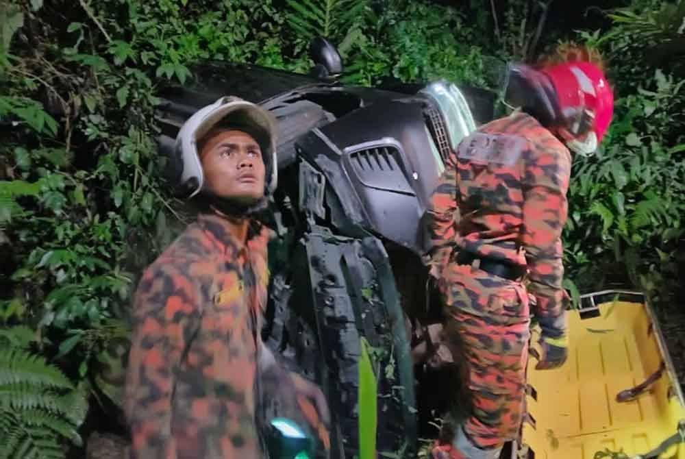 Pasukan bomba menjalankan operasi membawa keluar mangsa yang cedera dalam insiden kereta jatuh gaung di Jalan Pahang, Tapah. Foto ihsan Bomba Perak