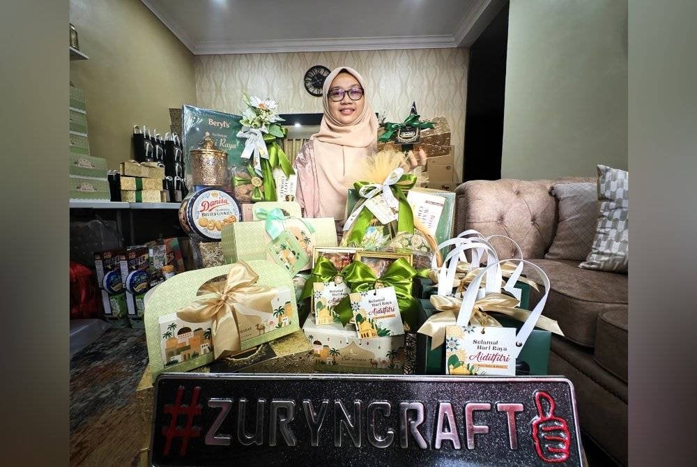 Zurina menunjukkan antara gubahan hamper dan cenderahati Aidilfitri yang dibuatnya.
