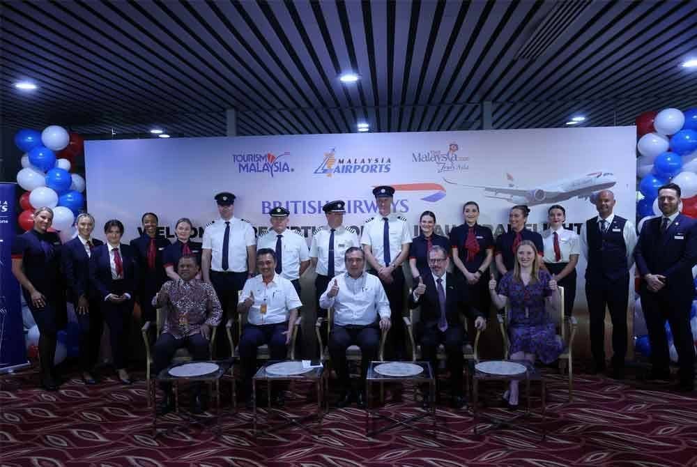 Anthony Loke (duduk, tengah) bergambar kenangan bersama anak-anak kapal British Airways pada Majis Sambutan Pesawat British Airways Boeing 787-900 di Lapangan Terbang Antarabangsa Kuala Lumpur (KLIA) Terminal 1 hari ini. - Foto: Bernama