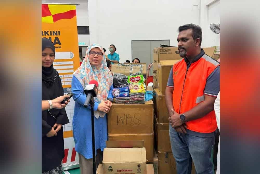 Anfaal Saari (dua dari kiri) ketika menyampaikan bantuan kepada wanita dan kanak-kanak di PPS Masjid Putra Heights, Subang Jaya pada Rabu.