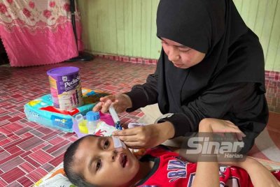 Azmira (kanan) memberikan susu kepada Muhamad Iman Hafiz.
FOTO SINAR HARIAN-ADILA SHARINNI WAHID