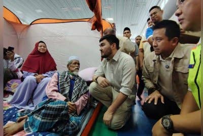 Tengku Amir memberi semangat kepada keluarga Ya'acob Yusof, antara mangsa yang masih dalam proses pemulihan di PPS Putra Heights.