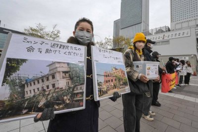Sukarelawan memegang sepanduk dan papan tanda meminta sumbangan untuk mangsa gempa bumi berukuran 7.7 magnitud baru-baru ini yang melanda Myanmar, di luar stesen kereta api Nagoya pada 1 April 2025. Foto AFP