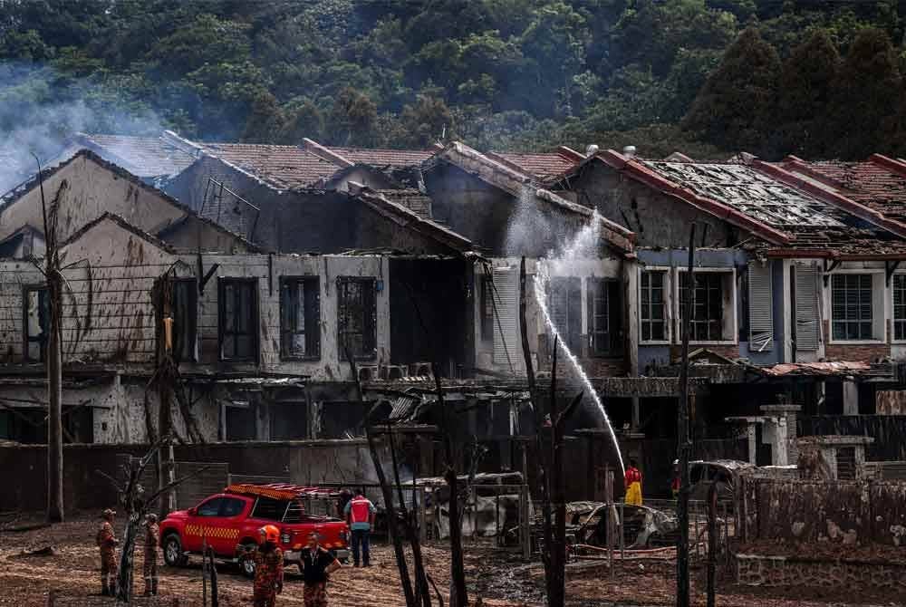 Anggota Jabatan Bomba dan Penyelamat Malaysia (JBPM) Selangor giat memadamkan sisa api di kediaman penduduk yang terlibat dalam kebakaran saluran paip gas di Jalan Putra Harmoni, Putra Heights, Subang Jaya, Selangor semalam - Foto: Bernama