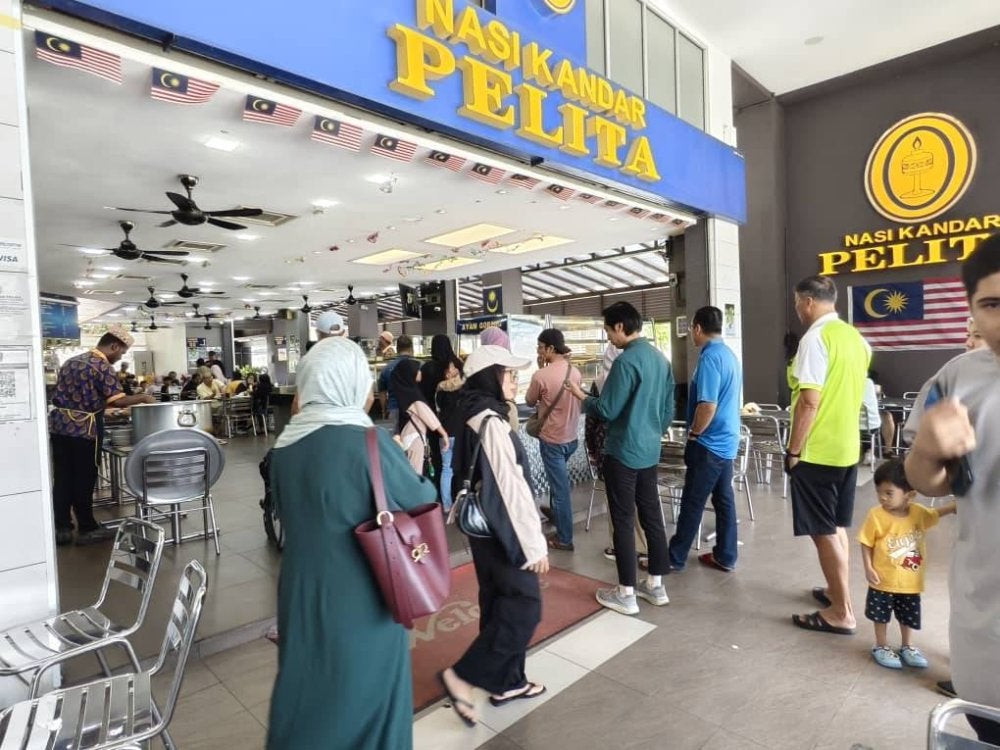 Orang ramai beratur menunggu giliran membeli nasi kandar.