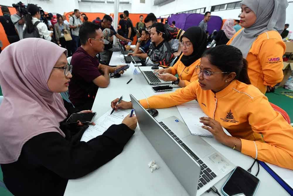 Mangsa-mangsa kejadian kebakaran saluran paip gas beratur bagi membuat pendaftaran maklumat peribadi di kaunter khidmat masyarakat yang dibuka ketika tinjauan di Pusat Pemindahan Sementara (PPS) di Masjid Putra Heights, pada Khamis. Foto Bernama