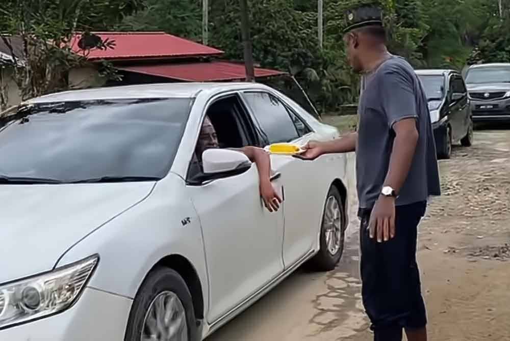 Rakan-rakan Mohamed Syawal turut sama membantu mengagihkan makanan tersebut bagi memastikan pergerakan kenderaan berjalan lancar.