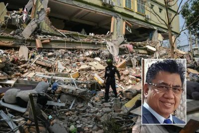 Seorang pekerja penyelamat berjalan di atas runtuhan ketika pasukan menjalankan operasi menyelamat penduduk yang terperangkap di pembangunan Kondominium Sky Villa yang musnah di Mandalay. Foto AFP (Gambar kecil: Azlan Adnan)