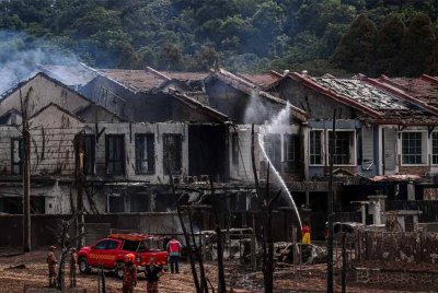 Anggota Jabatan Bomba dan Penyelamat Malaysia (JBPM) Selangor giat memadamkan sisa api di kediaman penduduk yang terlibat dalam kebakaran saluran paip gas di Jalan Putra Harmoni, Putra Heights, Subang Jaya, Selangor semalam - Foto: Bernama