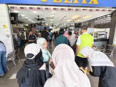 Orang ramai beratur menunggu giliran membeli nasi kandar.