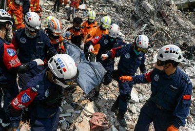 Penyelamat Myanmar dan China membawa mayat mangsa yang terperangkap di bawah runtuhan bangunan. Foto AFP