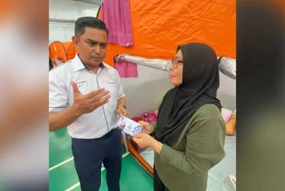 sumbangan itu diserahkan kepada Zurina Mohd Isa, 49, oleh pegawai Sekretariat Perantau Anak Pahang Syed Anas Syed Ali ketika melawatnya di pusat pemindahan sementara (PPS) Dewan Masjid Putra Heights pada Khamis. Foto Facebook Wan Rosdy