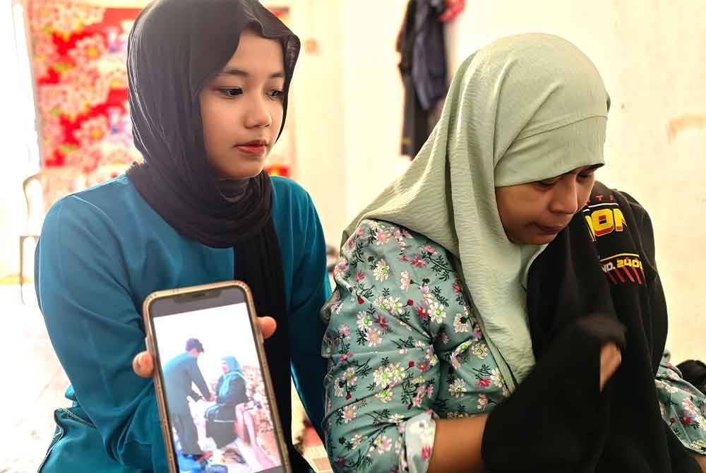 Nur Alini menunjukkan gambar Allahyarham bersalam dengan Rohani pada Aidilfitri tahun lalu