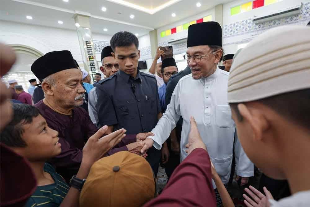 Anwar Ibrahim meluangkan masa bersalaman bersama jemaah selepas menunaikan solat Jumaat di Masjid Prima Saujana, Kajang hari ini. - Foto: Bernama