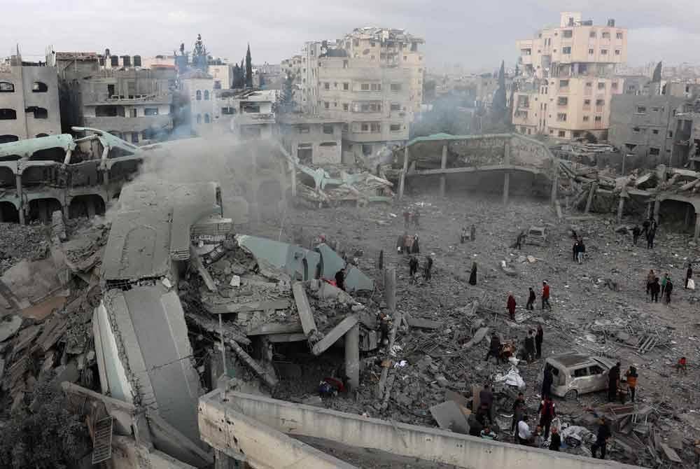 Warga Palestin memeriksa kawasan sekolah di Gaza yang musnah dibom Israel. Foto AFP