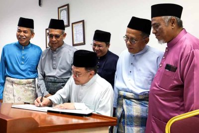 Anwar menandatangani buku pelawat sebagai simbolik lawatan beliau sebelum menunaikan solat Jumaat di Masjid Prima Saujana, Kajang. Foto Bernama