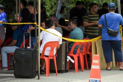 Penduduk yang juga merupakan mangsa kebakaran dilihat menunggu giliran untuk pulang ke kediaman masing-masing bagi mengambil barangan keperluan serta dokumen penting pada Jumaat. Foto Bernama