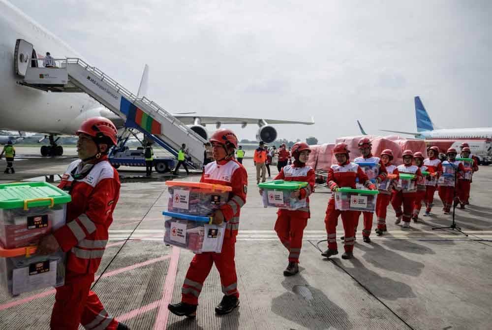 Anggota Palang Merah Indonesia (PMI) mengangkat kotak bantuan selepas upacara pelepasan misi bantuan kemanusiaan ke Myanmar di Pangkalan Udara Halim Perdanakusuma, Jakarta. Foto AFP