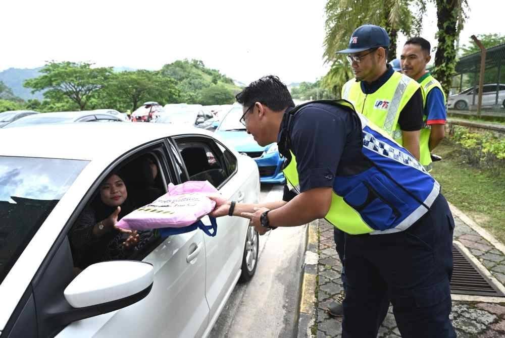 Mohd Zamri menyerahkan buah tangan kepada orang ramai sempena Ops Khas HRA Aidilfitri 2025 di Plaza Tol Gemuruh di Kuala Terengganu, pada Sabtu.