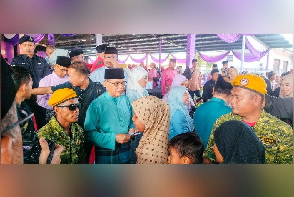 Wan Rosdy menyampaikan duit raya kepada kanak-kanak sempena Majlis Rumah Terbuka Aidilfitri DUN Jelai pada Sabtu.