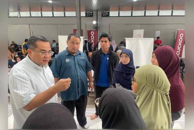 Sharifudin (kiri) melawat Ainaa Syazana yang kini ditempatkan di PPS Dewan Serbaguna Masjid Putra Heights.